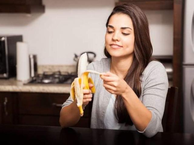 امرأة تأكل فاكهة الموز-ارشيفية