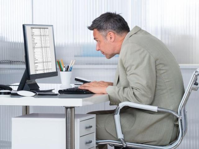 رجل يجلس بشكل خاطئ أثناء تصفح جهاز الكمبيوتر الخاص به