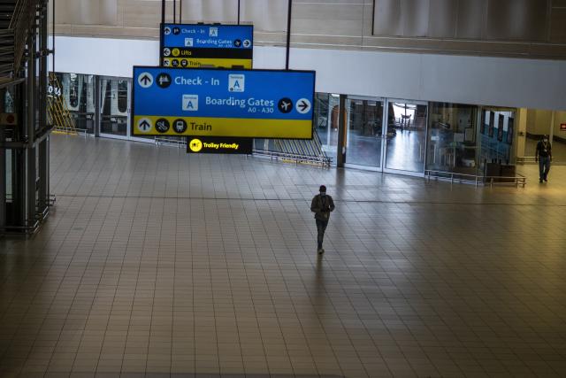 رجل يسير في جزء مهجور من مطار أو آر تامبو الدولي في جوهانسبرج ، جنوب إفريقيا ، يوم الاثنين