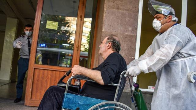عامل في مستشفى يدفع رجلاً على كرسي متحرك في مركز جريجور في أرمينيا