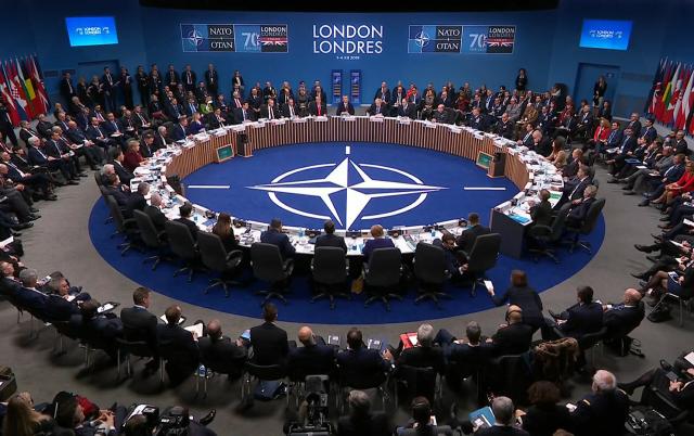 اجتماع قادة الناتو ويتوسطهم شعار الحلف 