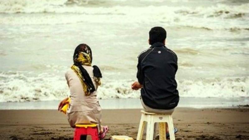 شاب وفتاة يجلسان على شاطئ البحر في الأردن- رويترز