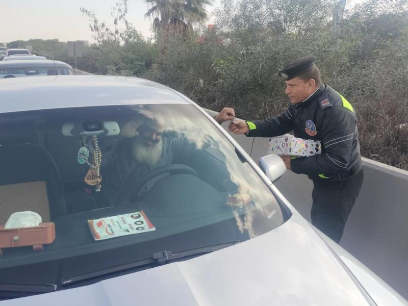 بالصور.. المرور يوزع ورودا وشيكولاتة على قائدي السيارات بمناسبة عيد الشرطة