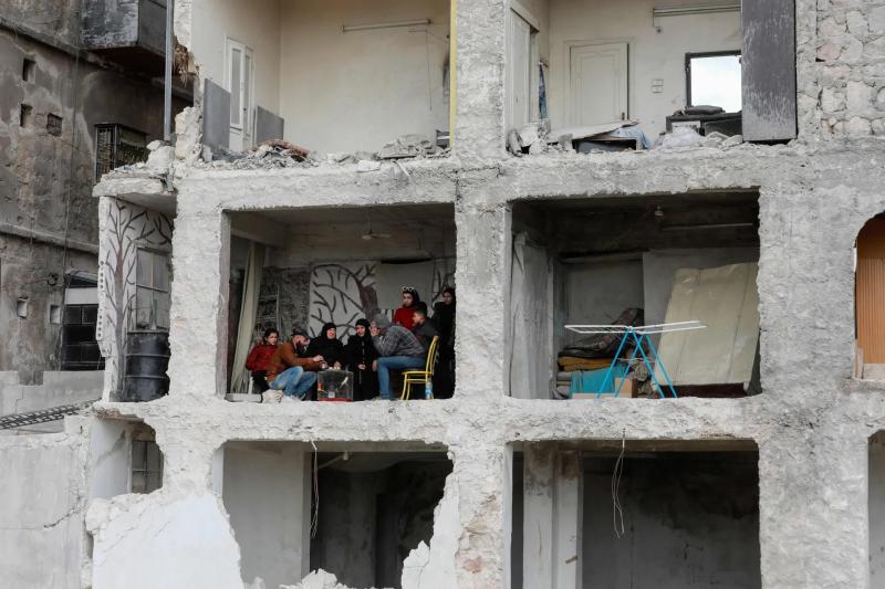 عائلة سورية تتناول الشاي على أنقاض منزلهم بعد الزلزال 