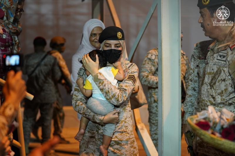جندية سعودية تحمل طفلا لحظة الإجلاء (وزارة الدفاع السعودية)