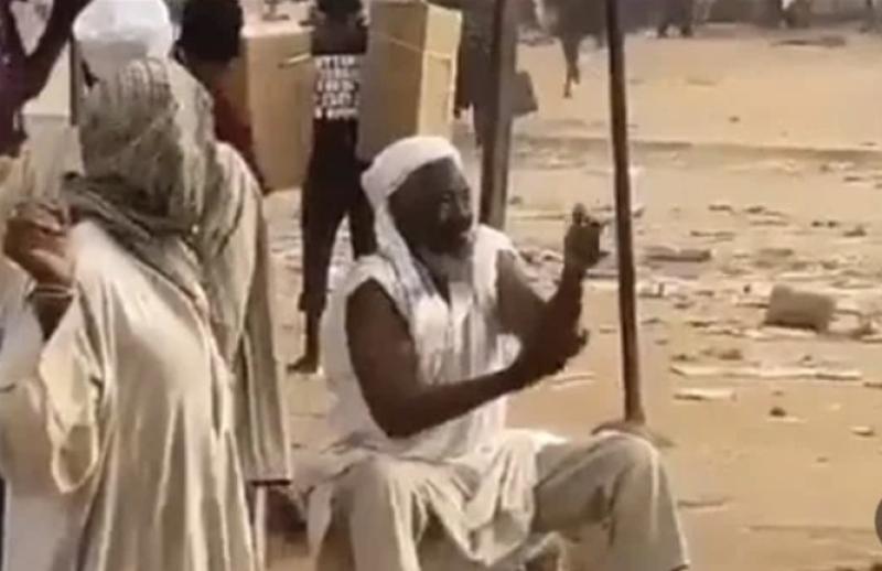 رجل مسن يتوضأ وسط عمليات النهب في السودان