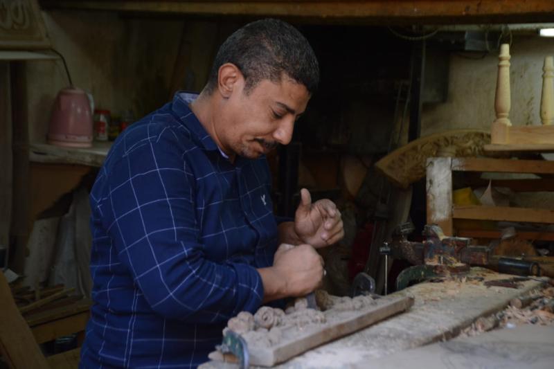 الأسطى ”محمد علي” يتفنن في النقش على الخشب والنحت عليه