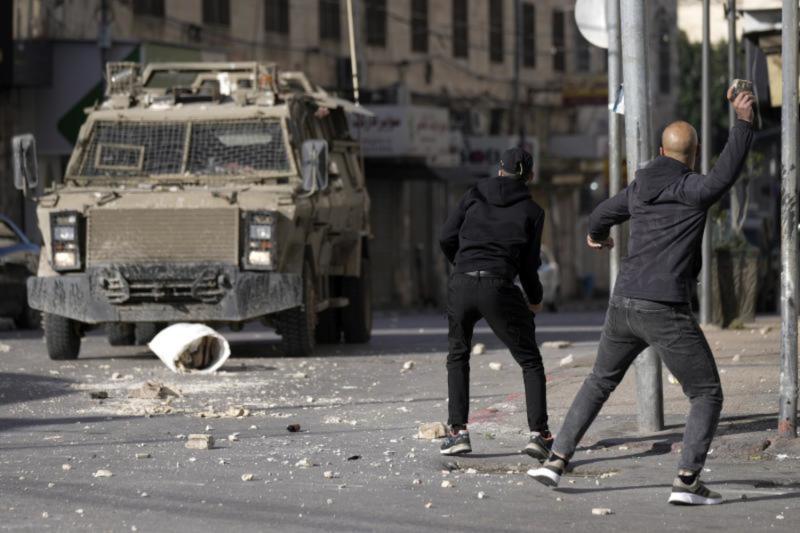 فلسطينيون يلقون الحجارة على قوات الاحتلال